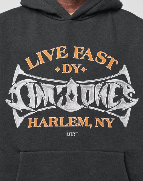 The LIVE FAST DIE YOUNG Live Fast Tribal Hooded is a black oversized hoodie with orange and white LIVE FAST DY LIMONE HARLEM, NY text and stylized silver graphic lettering at the center.