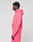 A young man stands in profile, wearing a bright pink LIVE FAST DIE YOUNG Basic Hooded Zip and matching pink shorts with subtle branding, set against a plain light gray background.