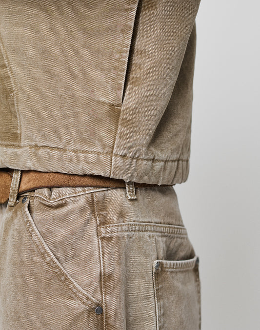 A close-up side view of a person wearing light brown denim jeans and a Faded Workwear Jacket by LIVE FAST DIE YOUNG, showcasing the fabric texture, seams, and a partially visible pocket.