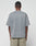 A man with short hair, facing away from the camera, wears the LIVE FAST DIE YOUNG Basic +49 Chest Tee in an oversize faded gray style and light beige shorts against a plain white background.