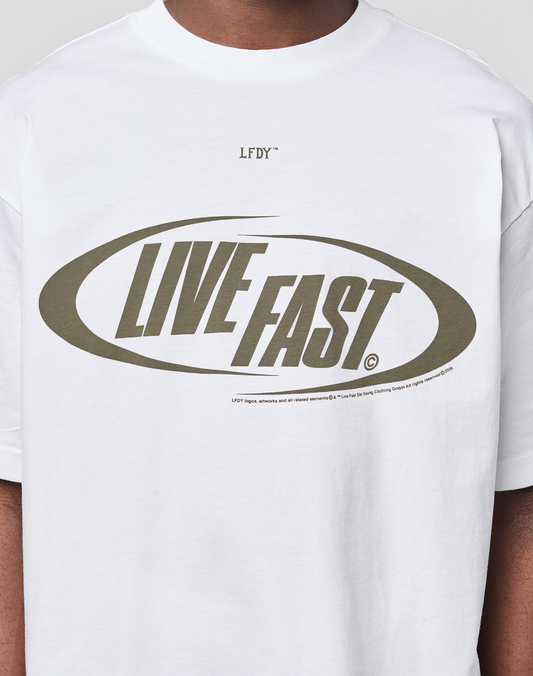 Someone wearing the LFDY Sphere Tee by LIVE FAST DIE YOUNG: an oversize white cotton T-shirt with "LIVE FAST" in bold olive letters inside an oval on the front, and "LFDY" printed above the design.