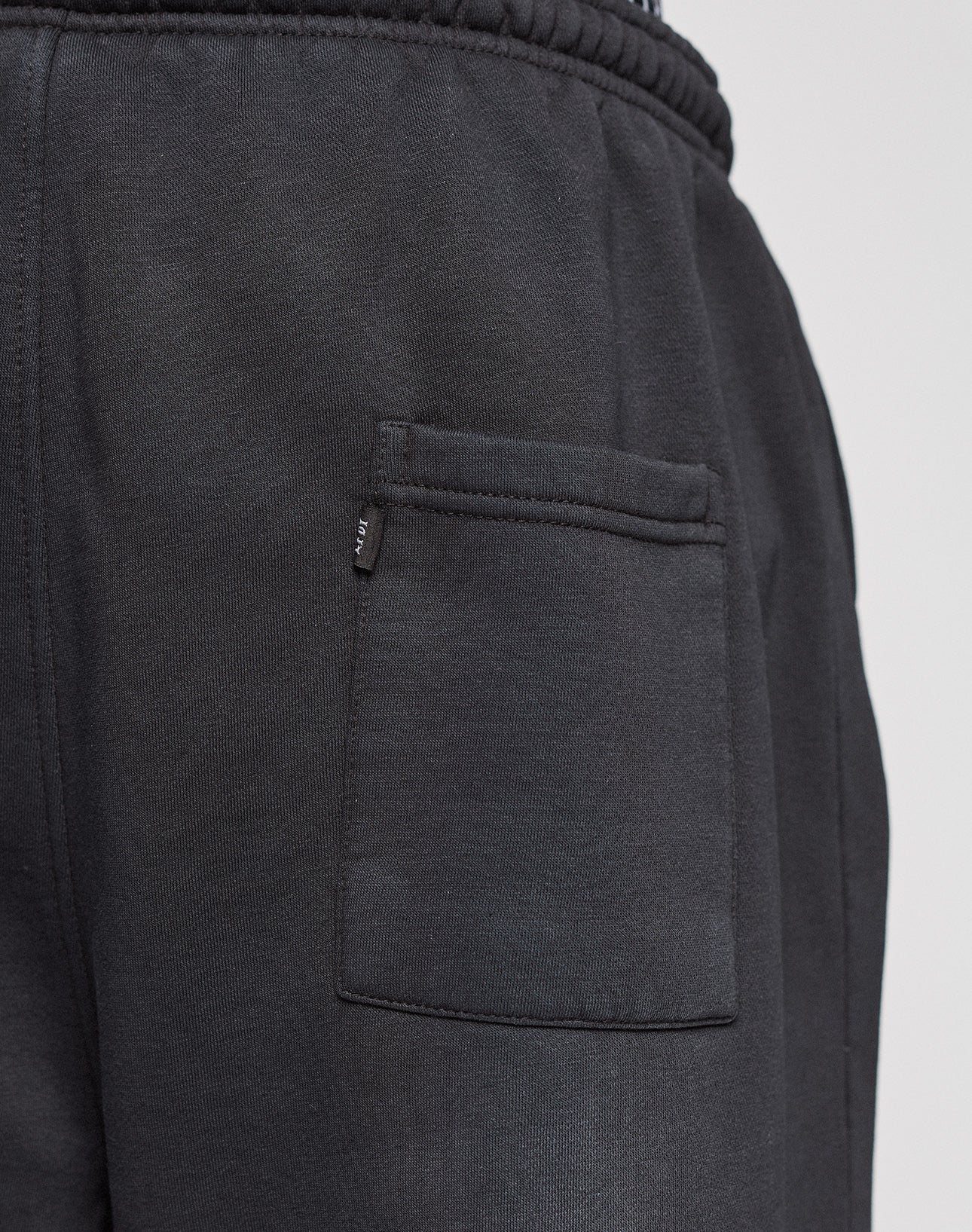 Close-up of the back pocket on the Live Fast Rhinestone Jogger by LIVE FAST DIE YOUNG, showing detailed stitching and a small black tag, all in a wide fit design for extra comfort.
