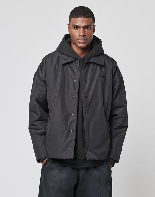 A man stands facing forward with his hands in his pockets, wearing the LIVE FAST DIE YOUNG Collar Winter Jacket over a black hooded sweatshirt, set against a plain light background.