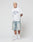 A man with short bleached blond hair wears the LFDY Boxy Jersey by LIVE FAST DIE YOUNG, featuring a bold frontprint, paired with light denim knee-length shorts, white socks, and white sneakers against a plain light background.