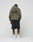 A person faces away, wearing the LIVE FAST DIE YOUNG Basic 360 Hooded in olive green with large black front and back print (oversize fit), black shorts, white socks, and white sneakers against a plain light gray background.