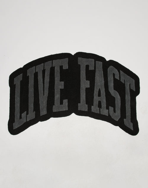 Text in bold, capitalized gray letters outlined in black reads LIVE FAST on a white background, slightly curved upward like the stylish Live Fast Carpet by LIVE FAST DIE YOUNG.