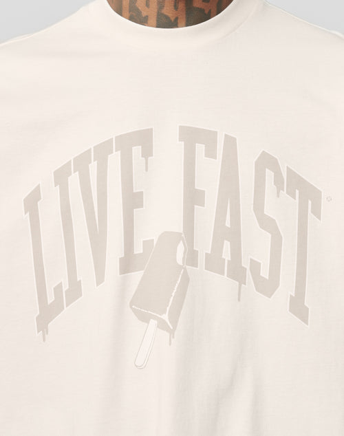 A close-up of the LIVE FAST DIE YOUNG Live Fast Ice Tee, an oversize white Baumwolle t-shirt featuring bold, arched LIVE FAST lettering and a melting popsicle graphic below.