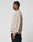 A man in profile against a plain background wears the beige Live For It Sweater by LIVE FAST DIE YOUNG, made from 100% Baumwolle, paired with black pants. His left arm hangs at his side and his expression is neutral.