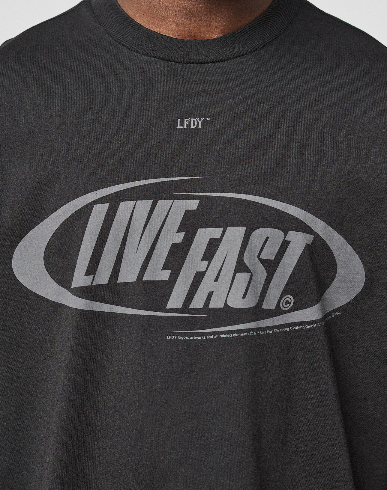 A close-up of the LFDY Sphere Tee by LIVE FAST DIE YOUNG, featuring "LIVE FAST" in bold letters inside an oval, LFDY above the design, and an Oversize Fit for modern streetwear style.