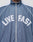A person is wearing the LFDY Arch Trackjacket by LIVE FAST DIE YOUNG, a blue zip-up jacket with white piping, elastic cuffs, and LIVE FAST printed in bold white letters on the chest.