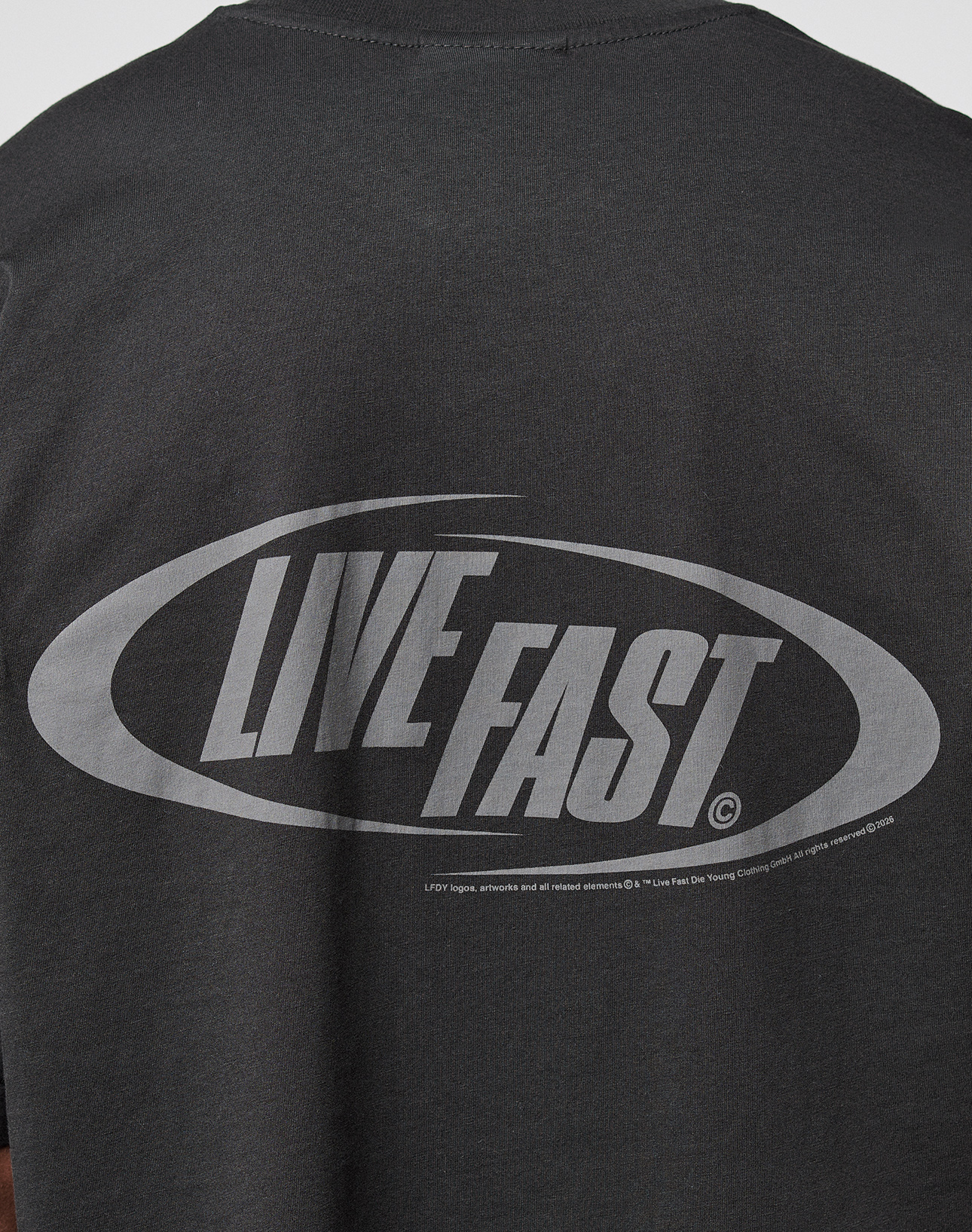 The LFDY Sphere Tee by LIVE FAST DIE YOUNG is a black oversized cotton T-shirt with striking front and back prints, including a large oval graphic and bold light gray LIVE FAST text on the back.