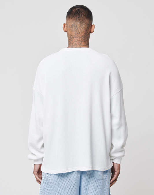 A person with closely shaved hair and neck tattoos is shown from behind, wearing a LIVE FAST DIE YOUNG Basic Waffle Longsleeve in white and light blue mesh shorts against a plain light background.