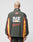 A person with short, bleached hair is seen from behind wearing the LIVE FAST DIE YOUNG Westend Trackjacket, a regular fit dark green polyester jacket with yellow and red stripes and a large Multi-Logo design reading 10, DIE, and Westend on the back.
