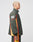 A person with short blond hair is standing sideways, wearing the LIVE FAST DIE YOUNG Westend Trackjacket in dark green polyester with red and yellow stripes and DIE plus Westend printed on the back.