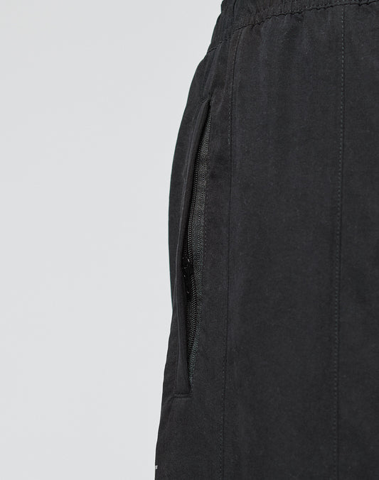 Close-up of the side pocket, waistband with elastikbund, and partially open zipper on black LFDY Trackpants by LIVE FAST DIE YOUNG. The background is plain light gray.