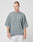 A young man with short hair wears the Cropped Oversize Tee from LIVE FAST DIE YOUNG, made of 100% Baumwolle, along with light gray sweatpants, standing against a plain white background and looking slightly to his left.