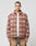 A man faces forward wearing the LIVE FAST DIE YOUNG Vintage Padded Flannel in red and beige plaid over a white shirt and brown pants, set against a plain light gray background.