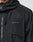 Close-up of the Live Fast Nylon Jacket by LIVE FAST DIE YOUNG, featuring a black, crinkled fabric with a hood and zipper. A gray LIVE FAST Silikon-Print appears on the chest. Only part of the wearer’s neck and jaw is visible. Oversized fit.