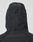 A close-up of the back of the LIVE FAST DIE YOUNG Live Fast Nylon Jacket, an oversized black hooded jacket with a cinch cord and toggle at the hood, shown against a plain light background.