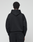 Seen from behind against a plain light background, a person with short curly hair wears the LIVE FAST DIE YOUNG Basic Livefast Hooded sweatshirt and matching black cotton pants in an oversize fit.