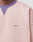A close-up shows the lower neck and upper chest of a person wearing the LIVE FAST DIE YOUNG Copyright Sweater—an oversize light pink sweatshirt with a small black LFDY™ logo, a purple ribbed contrast collar, and visible topstitching.