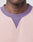Close-up of a persons neck and upper chest wearing the LIVE FAST DIE YOUNG Copyright Sweater, featuring a light pink design with a ribbed, V-notched purple neckline and contrasting topstitching for standout style.