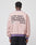 A person wears the LIVE FAST DIE YOUNG Copyright Sweater—an oversize fit, light pink with purple contrast cuffs and waistband. The back displays bold black LIVE FAST DIE YOUNG COPYRIGHT ©013 text and a smiling cartoon ghost.