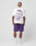 A man faces away, wearing the LFDY Originals Tee by LIVE FAST DIE YOUNG—a white oversize Baumwolle shirt with a bold purple backprint portrait—paired with purple shorts, white LIV socks, and white sneakers against a plain light background.