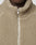 Close-up of a person wearing the beige LFDY Teddy Jacket by LIVE FAST DIE YOUNG in Oversize Fit, featuring a partially zipped silver zipper. Only the lower half of their face and neck are visible.