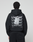 A person wearing the LIVE FAST DIE YOUNG Basic Evidence Hooded Zip in an oversize fit, featuring bold white branding, paper-like graphic, small symbols, and subtle distressing on the back, stands against a plain background.