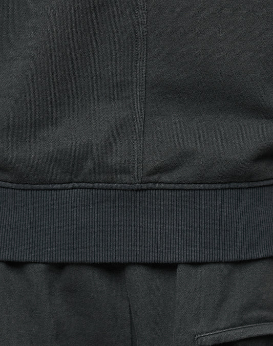 Close-up of the bottom hem and ribbed waistband of the LIVE FAST DIE YOUNG LFDY Lightweight Hooded Zip, showing stitching details with matching black Regular Fit pants below. Made from 100% Baumwolle for comfort.