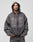 A man wears the LIVE FAST DIE YOUNG Tribal Denim Hooded Zip in gray with matching pants, hood up, hands in his pockets, standing against a plain light gray background and looking directly at the camera.