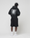 A person wears the LIVE FAST DIE YOUNG Basic Evidence Hooded Zip in black, paired with black shorts, white socks, white sneakers, and a black cap, standing with their back to a plain light background.