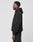A man stands in profile against a plain background, wearing an oversized fit black Live Fast Garment Hooded hoodie and black pants by LIVE FAST DIE YOUNG, both in soft Baumwolle. A subtle flag-label detail accents the minimalist look.