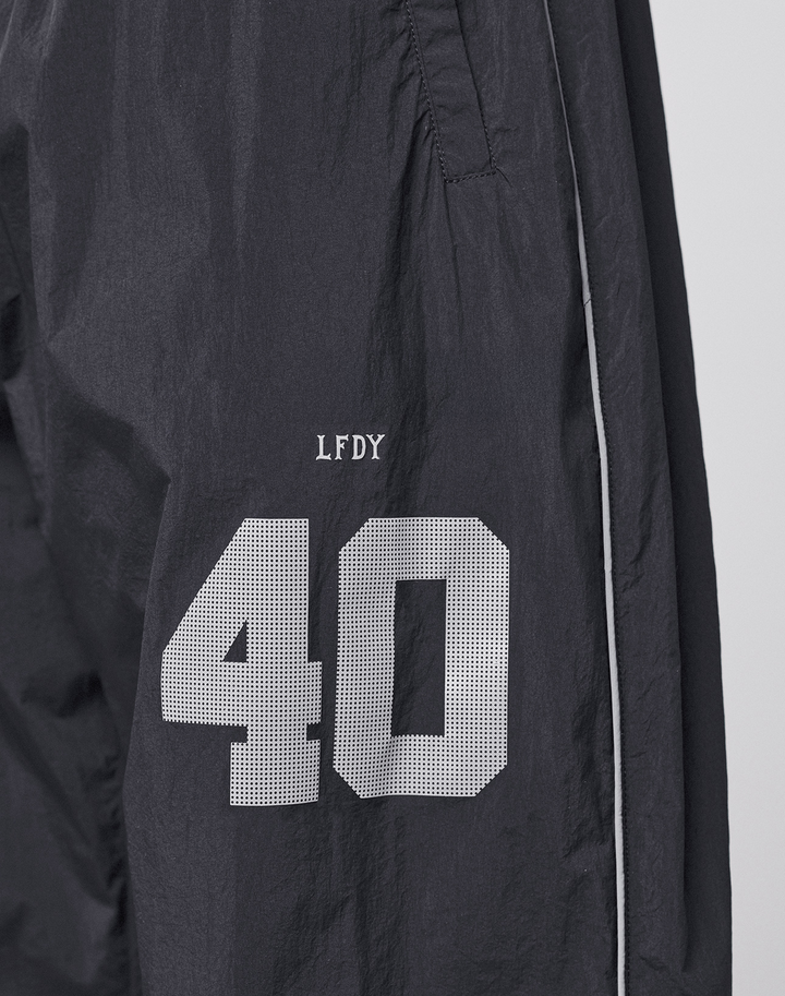 The LFDY Performance Trackpants by LIVE FAST DIE YOUNG feature black nylon fabric, white piping, and a reflective print. A white number 40 with "LFDY" above it appears on the left thigh for standout style.