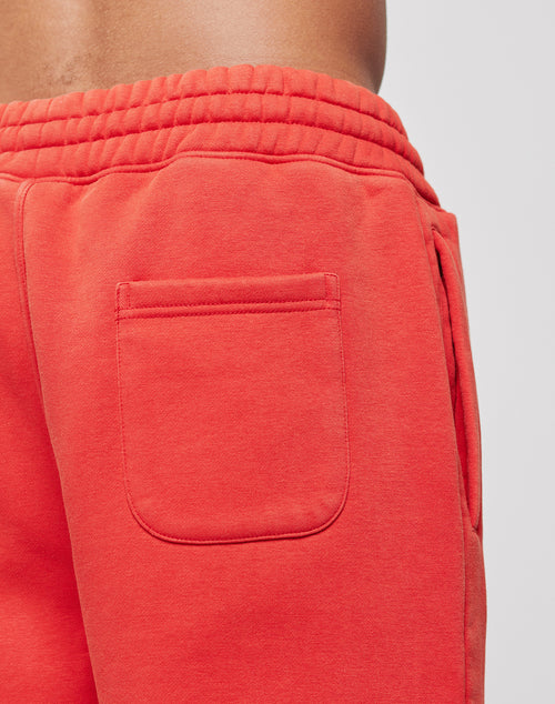Close-up of a person wearing LIVE FAST DIE YOUNGs LFDY Haters Jogger in red, featuring an elastic waistband, wide fit, and back pocket. The soft Baumwolle fabric is visible; only the lower torso and upper legs are shown.