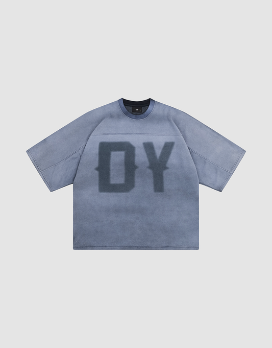 The LIVE FAST DIE YOUNG Faded Waffle Jersey is a loose, oversized, short-sleeve blue-gray t-shirt made from 100% Baumwolle, featuring large dark DY letters in a faded print on the front, laid flat on a light gray background. | plain