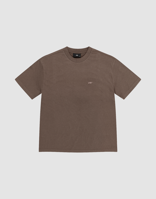 The LFDY Flash Tee by LIVE FAST DIE YOUNG is an oversize brown short-sleeve t-shirt with a crew neck, made from soft cotton-slub fabric. It features a small white LEFT logo on the left chest and is shown on a light gray background.