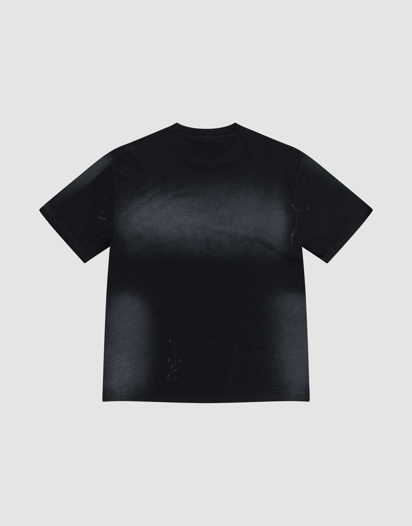 The Live Fast Rivet Tee by LIVE FAST DIE YOUNG is a black, oversized short-sleeve t-shirt with a faded, slightly distressed look and hand-applied spray effect, made from 100% cotton. Pictured flat on a light gray background with its back visible.