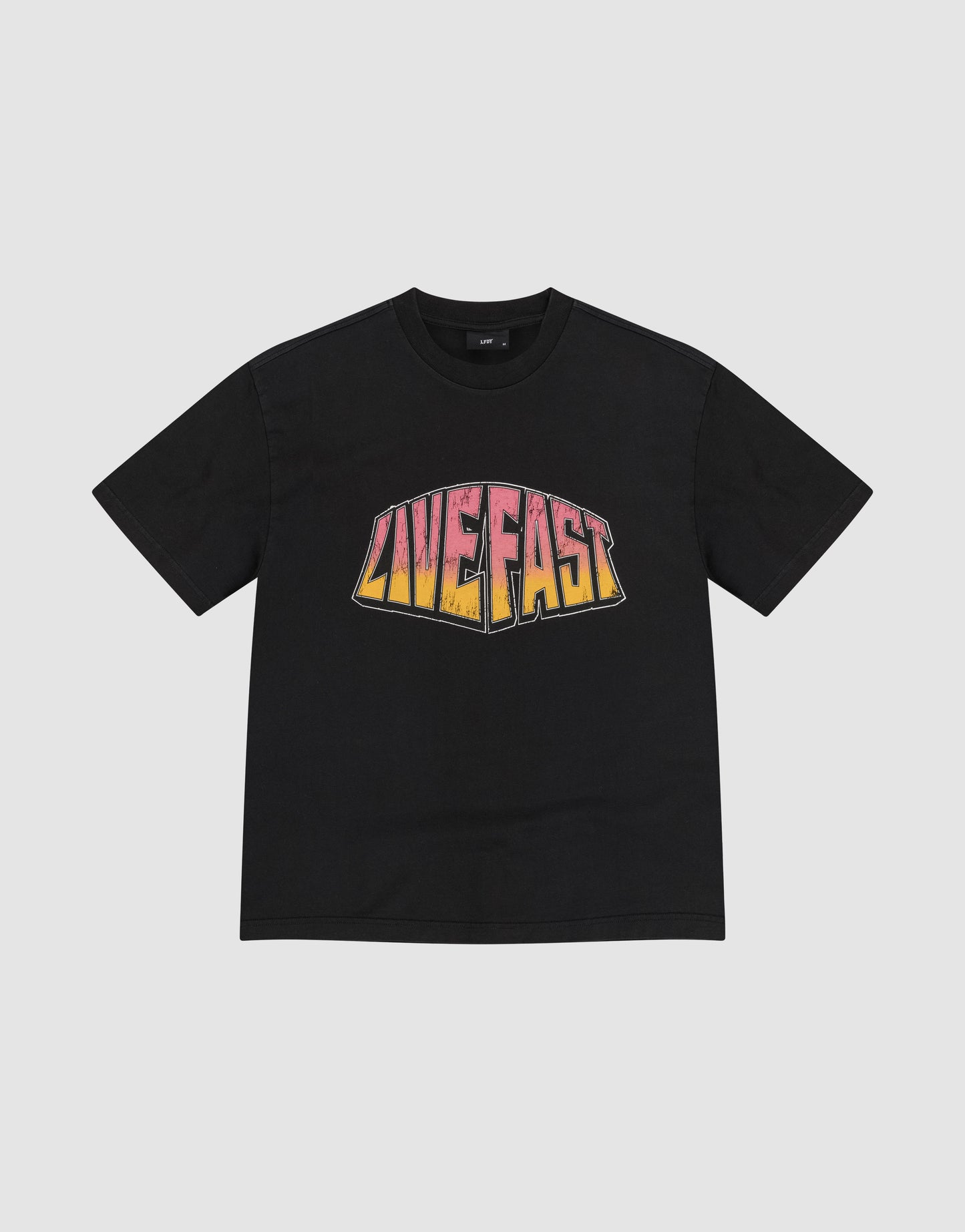 The LFDY Emblem Tee by LIVE FAST DIE YOUNG is a black oversize t-shirt with "LIVE FAST" in bold pink, orange, and yellow gradient print on the chest. Made from 100% Baumwolle and shown flat on a plain light gray background.