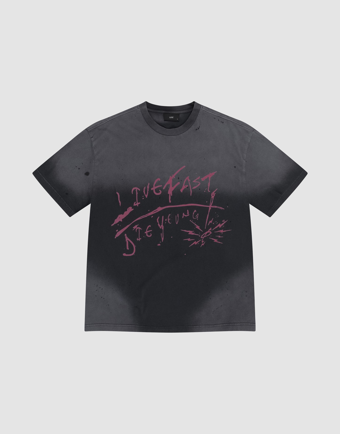 The LFDY Scribble Tee by LIVE FAST DIE YOUNG is a faded black 100% cotton shirt featuring pink graffiti "LIVE FAST DIE YOUNG" text and handmade spray-effect splatters around the lettering.