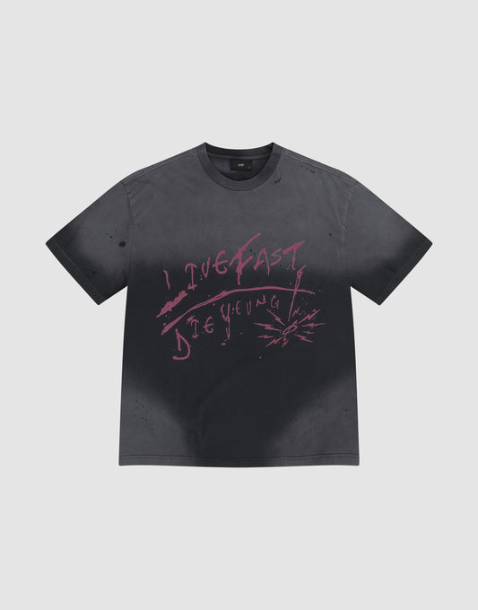 The LFDY Scribble Tee by LIVE FAST DIE YOUNG is a faded black 100% cotton shirt featuring pink graffiti "LIVE FAST DIE YOUNG" text and handmade spray-effect splatters around the lettering. | plain