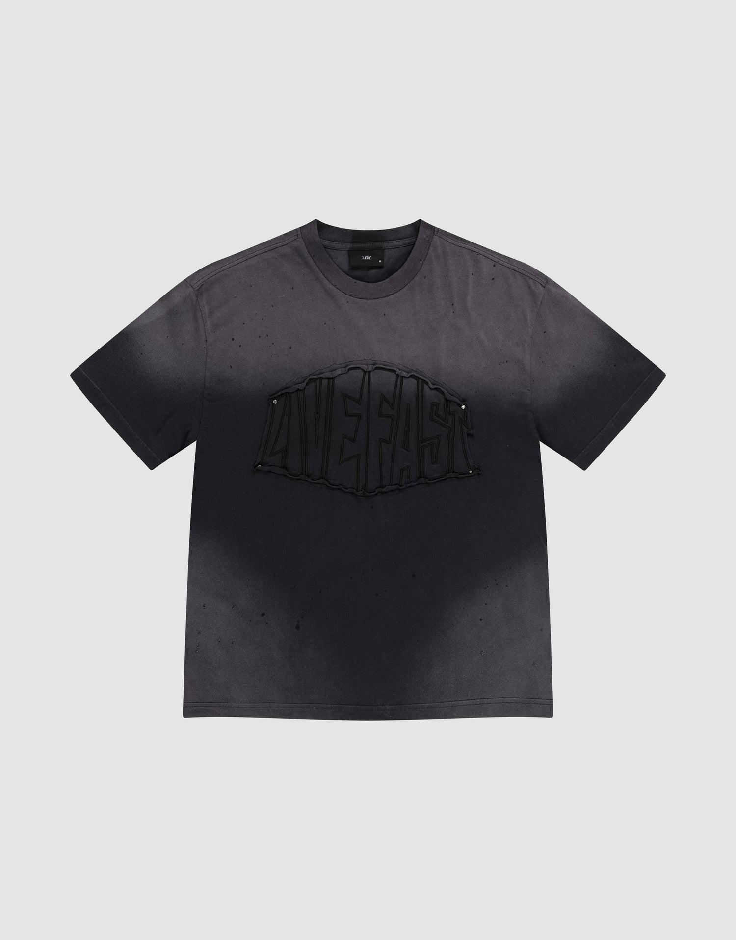 The LFDY Emblem Patch Tee by LIVE FAST DIE YOUNG is a black oversized jersey T-shirt made from 100% cotton, featuring a bold raised 'LIVE FAST' graphic, distressed look with subtle speckles, and a signature logo patch. | plain