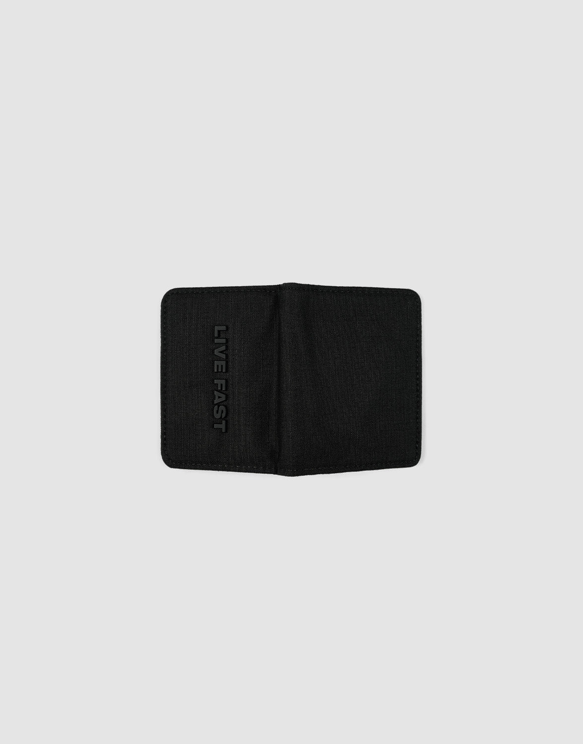 The LFDY Cardholder by LIVE FAST DIE YOUNG is a black bifold wallet with card slots, shown open on a light gray background. "LIVE FAST" is embossed vertically on the left inner side.