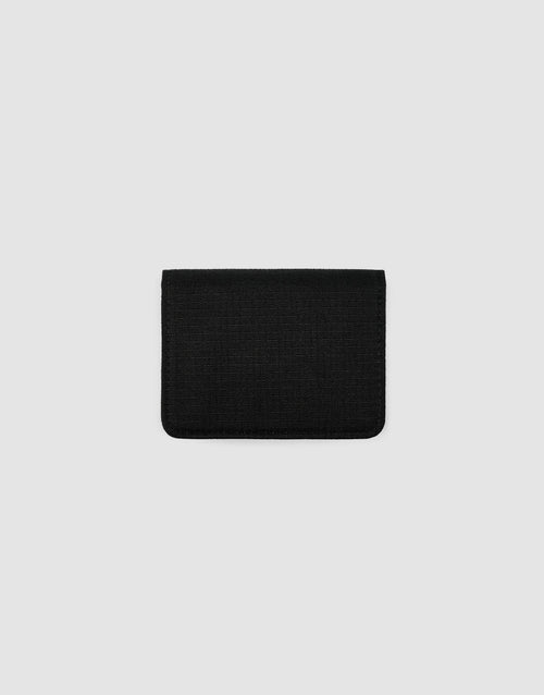 The LFDY Cardholder by LIVE FAST DIE YOUNG, a small rectangular black fabric wallet with Druckknopf-Verschluss, is centered on a plain light gray background, closed to display its minimalist design.