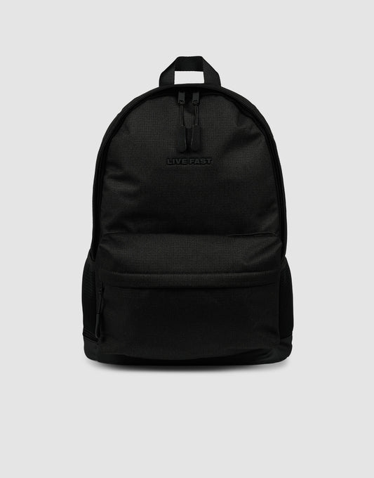 The LFDY Backpack by LIVE FAST DIE YOUNG is a plain black rucksack (19L) with a front zip pocket, small top handle, embossed "LIVEFAST" logo, and verstellbare Schultergurte, shown on a light gray background.