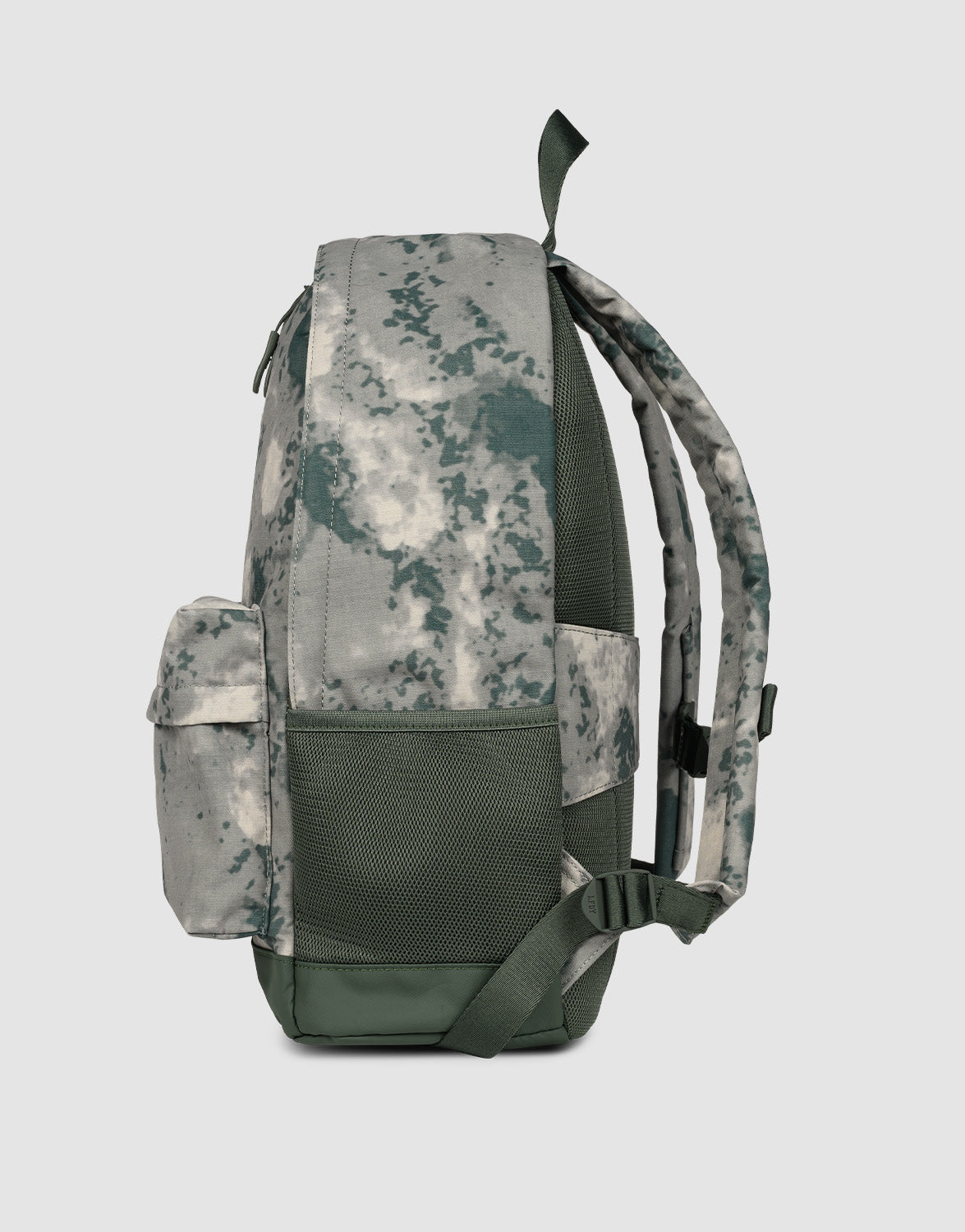 A side view of the LFDY Backpack by LIVE FAST DIE YOUNG in green-gray camouflage, with a front pocket, mesh side pocket, adjustable shoulder straps, top handle, and 19L capacity shown against a plain light background.