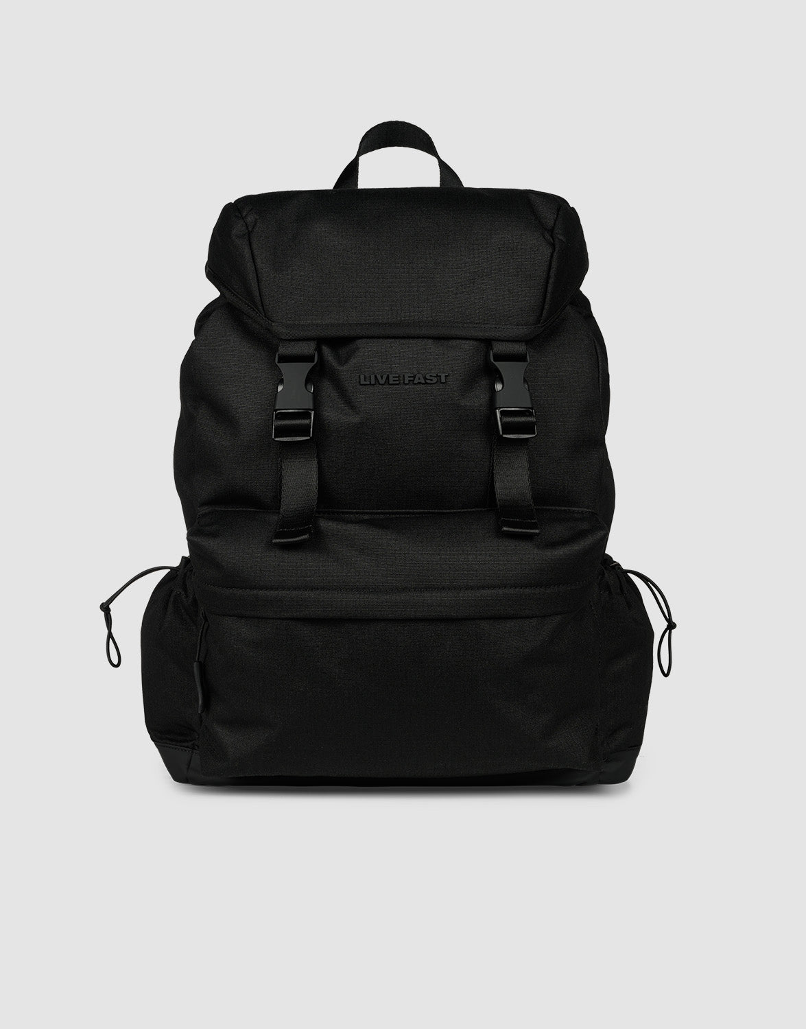 The LFDY Travel Backpack by LIVE FAST DIE YOUNG is a black 25L rucksack featuring adjustable shoulder straps, a top flap, two front buckles, side drawstring pockets, and a top handle, shown against a plain light gray background.