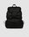 The LFDY Travel Backpack by LIVE FAST DIE YOUNG is a black 25L rucksack featuring adjustable shoulder straps, a top flap, two front buckles, side drawstring pockets, and a top handle, shown against a plain light gray background.