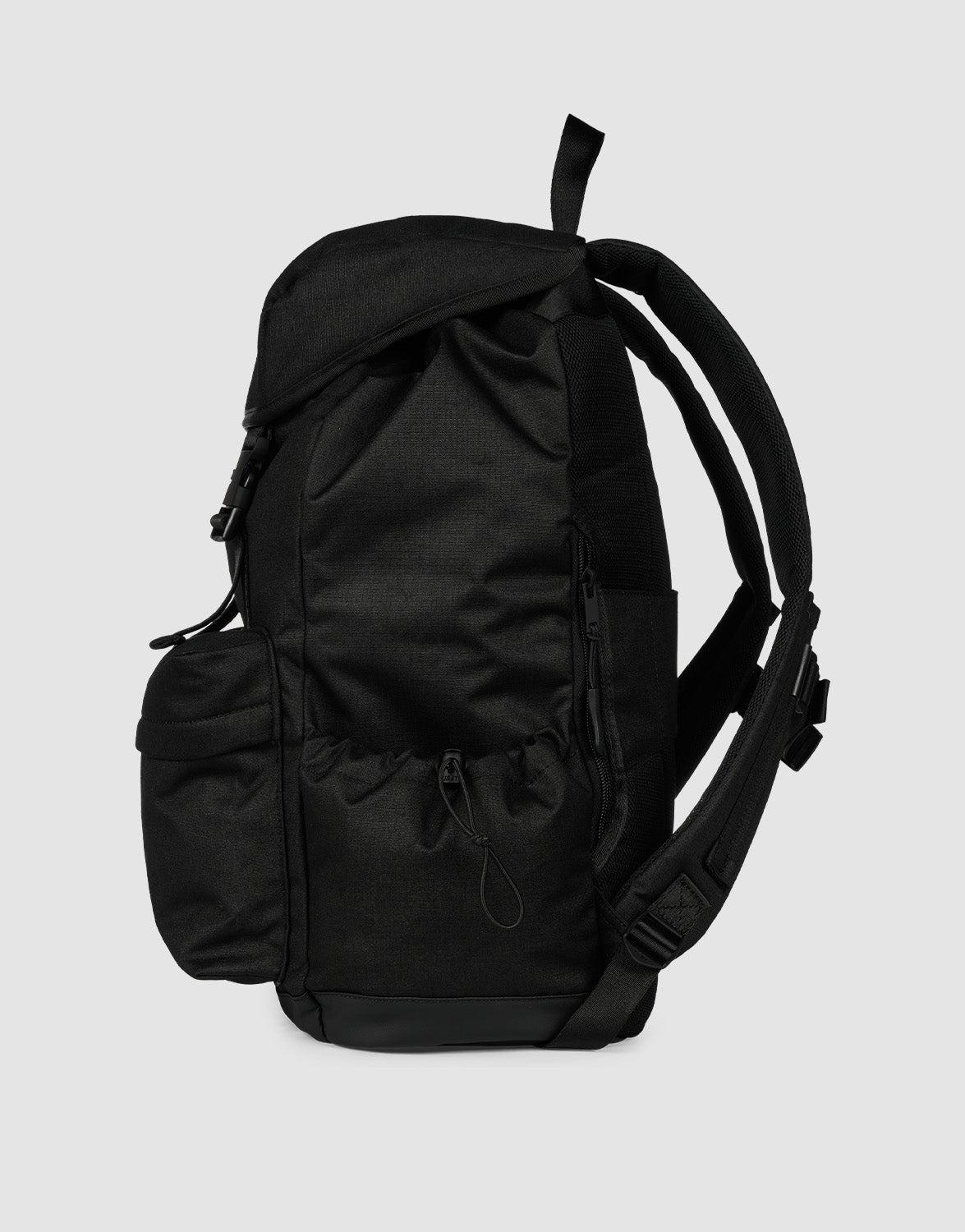 The LFDY Travel Backpack by LIVE FAST DIE YOUNG is a 25L laptop rucksack with multiple zippered compartments, side pockets, and adjustable shoulder straps, shown from the side against a plain light gray background.